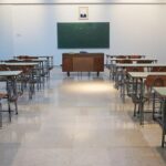 Sala de aula com carteiras e lousa